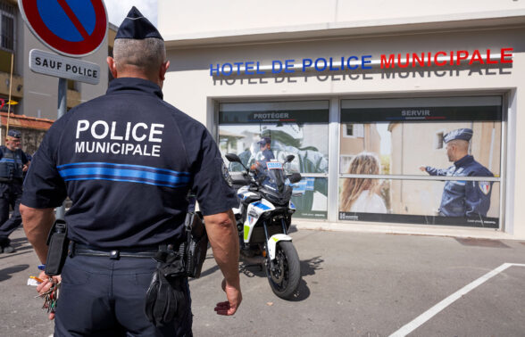 Policier municipal de dos, face à l'Hôtel de police municipale d'Aubagne
