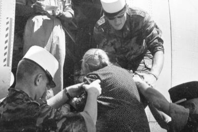 Des képis blancs aident une dame âgée à monter dans un petit avion - Agrandir l'image 2 sur 2, fenêtre modale