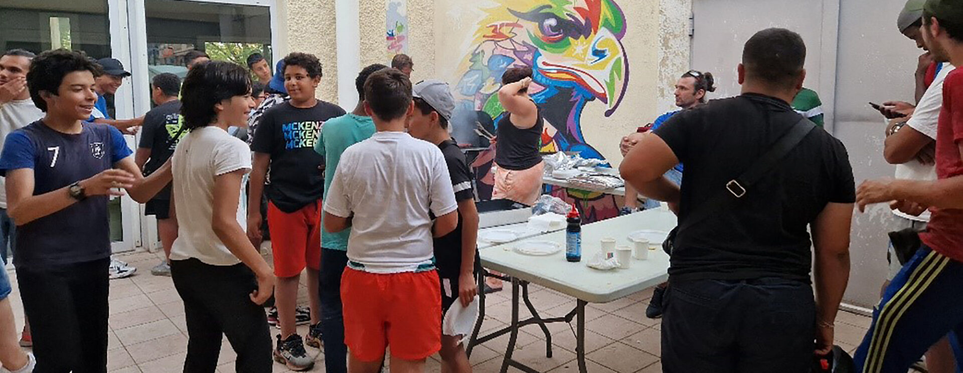 Des jeunes partagent un repas dans la cour intérieure de l'Espace Art & Jeunesse.