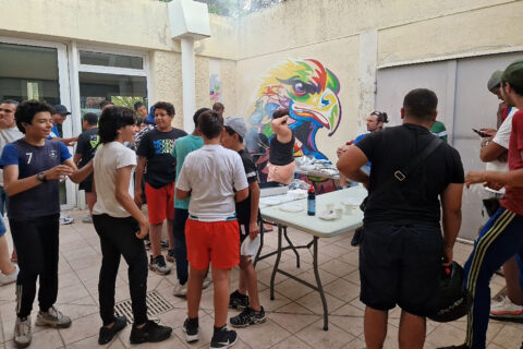 Des jeunes partagent un repas dans la cour intérieure de l'Espace Art & Jeunesse.