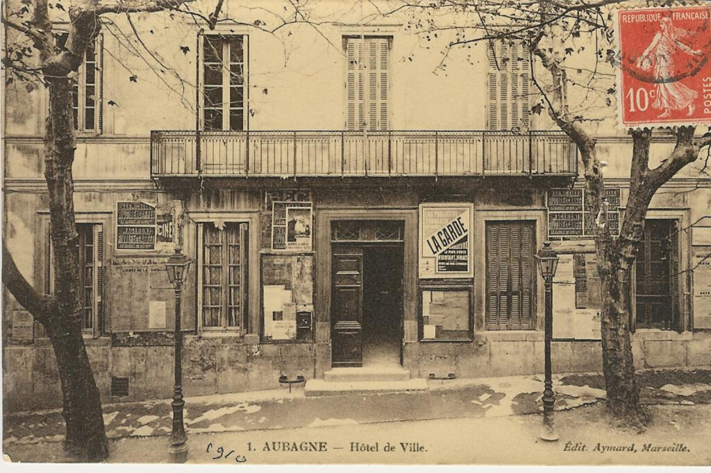 Façade avec un balcon au 1er étage et des affiches au rez-de-chaussée - Agrandir l'image, fenêtre modale