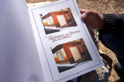 Photo du livre ouvert de Louis Douard qu'il tient dans ses mains avec la boulangerie de la rue Marceau - Agrandir l'image 3 sur 3, fenêtre modale