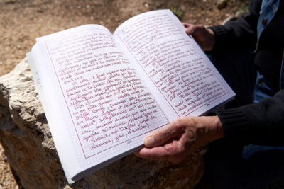 Photo du livre ouvert de Louis Douard qu'il tient dans ses mains - Agrandir l'image 2 sur 3, fenêtre modale