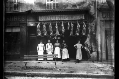La famille Azan pose devant sa boucherie où l'on voit des carcasses d'animaux suspendues - Agrandir l'image 3 sur 3, fenêtre modale