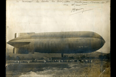 Un long dirigeable est posé dans la plaine. On distingue des gens en dessous - Agrandir l'image 1 sur 9, fenêtre modale