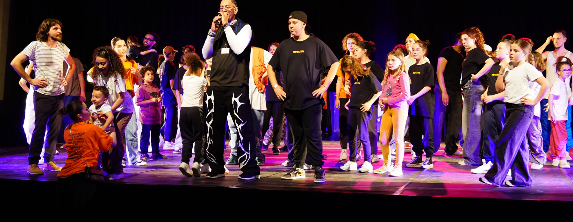 Miguel Nosibor entouré d'enfants sur la scène de l'Espace des Libertés.