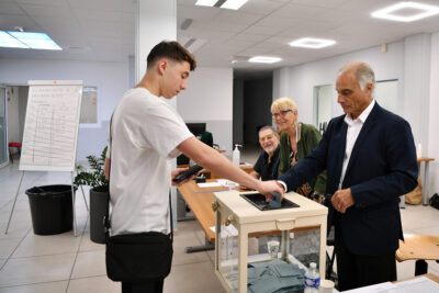 Un jeune homme vote au bureau n°1 situé dans la mairie annexe, rue de la Liberté, à l'occasion du 1er tour des législatives 2024 - Agrandir l'image 1 sur 4, fenêtre modale