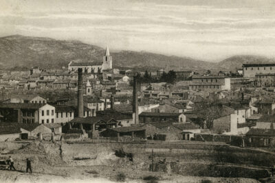 Au premier plan, une carrière d'argile. Au second, les toits d'Aubagne d'où dépassent quelques cheminées d'usines. On aperçoit la tour de l'horloge sur la gauche, le clocher de l'Observance, la chapelle de l'Œuvre de Jeunesse Saint-Louis, l'église paroissiale et la chapelle des Pénitents noirs. - Agrandir l'image 6 sur 18, fenêtre modale