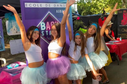 4 jeunes danseuses lèvent les bras en l'air en souriant devant le stand de leur association "Backstage danse" sur l'allée du Bras d'Or, à l'occasion de la fête des associations et du sport le 9 septembre 2023 - Agrandir l'image, fenêtre modale