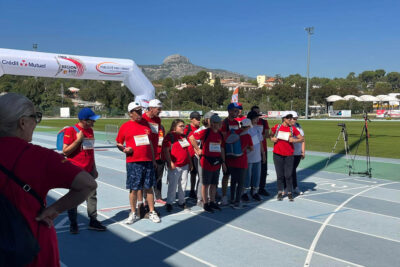 Une douzaine de participants à l'Effort à l'unisson portant des t-shirts rouges sont regroupés sur la piste bleue du stade de Lattre de Tassigny avec le Garlaban en arrière-plan se détachant dans un beau ciel bleu - Agrandir l'image 4 sur 6, fenêtre modale