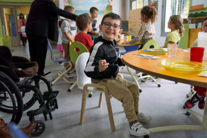 Mathis, petit garçon souriant et portant des lunettes, assis à une table de la cantine de l'école Mermoz à Aubagne - Agrandir l'image, fenêtre modale