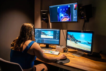 Une étudiante travaille dans un studio de la SATIS avec 3 écrans face à elle - Agrandir l'image, fenêtre modale