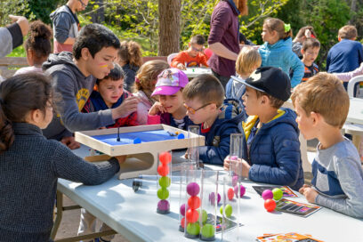Printemps des droits aux Espillières en 2019. Des enfants rassemblés autour d'une table colorée. - Agrandir l'image, fenêtre modale