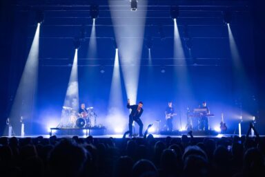 Julien Lieb chante sur scène avec ses musiciens en arrière plan