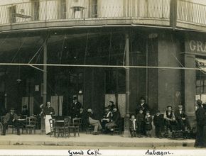Des hommes et des femmes sont attablés autour des petites tables du café sur une carte postale de 1910 - Agrandir l'image, .JPG 744,4 Ko (fenêtre modale)