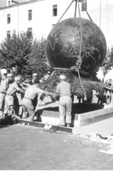 Des soldats aident à déplacer le Monument aux Morts (un gros globe terrestre) qui est tenu par des cordes et soulevé par une grue - Agrandir l'image, .JPG 336 Ko (fenêtre modale)