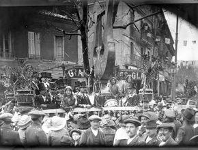 Une lyre géante est posée sur le char où des hommes en chapeau haut-de-forme sont couverts de confetti. - Agrandir l'image, .JPG 577,4 Ko (fenêtre modale)